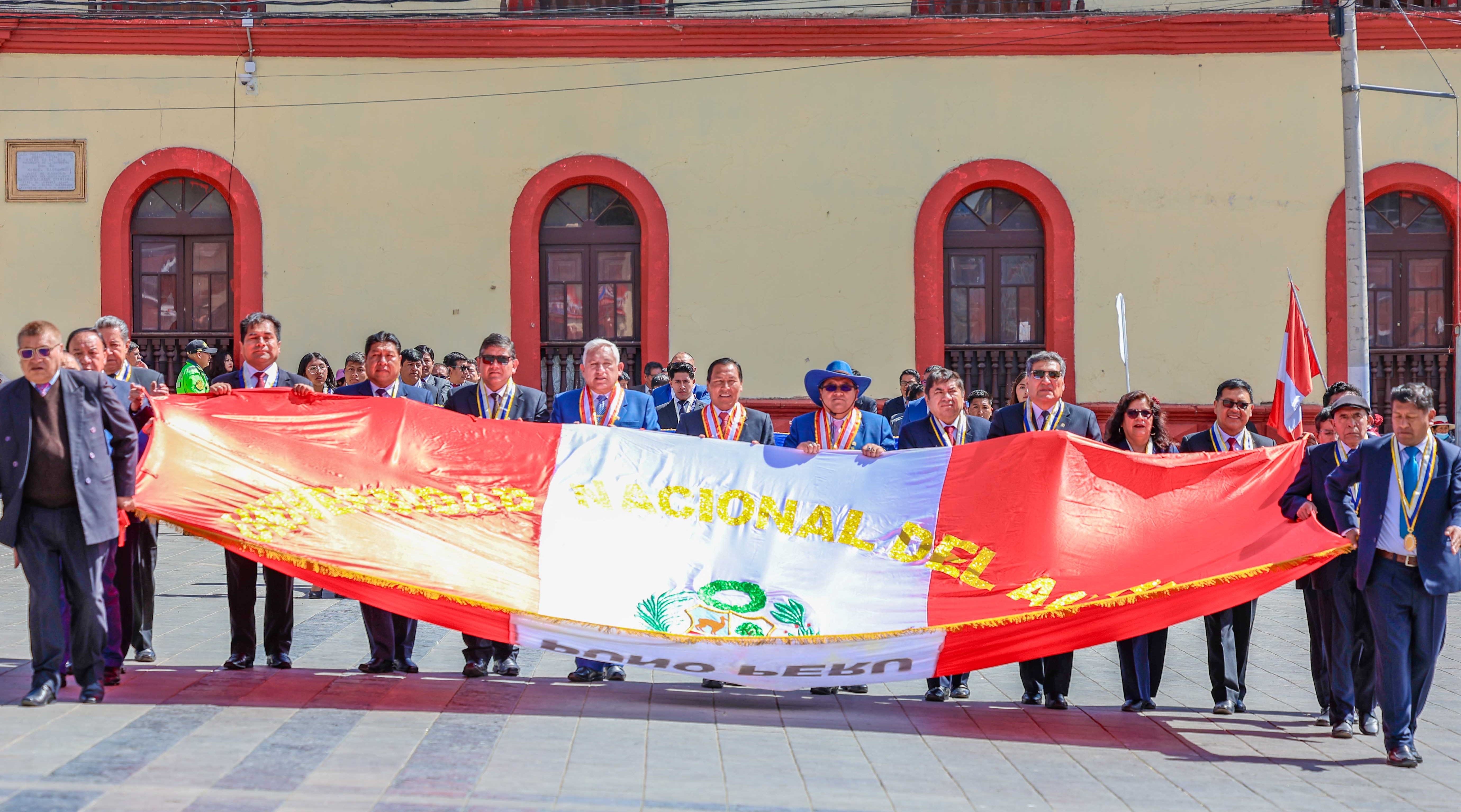 En el marco del 169 aniversario institucional, que será el próximo 29 de agosto, la Universidad Nacional del Altiplano de Puno, participó en la ceremonia de izamiento del Pabellón Nacional y en el desfile cívico militar desarrollado en la Plaza Mayor de la ciudad. El acto fue encabezado por el Rector, Dr. Paulino Machaca Ari, quien, acompañado de los Vicerrectores, Dr. Mario Cuentas Alvarado y Dr. Ariel Velazco Cárdenas, el director de la Escuela de Posgrado, Dr. Walter Tudela Mamani, decanos de facultades,